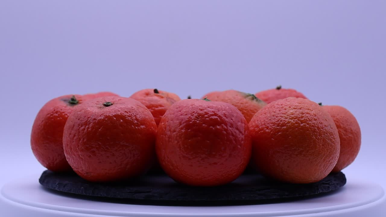 Fresh mandarin orange fruit rotating on a turntable