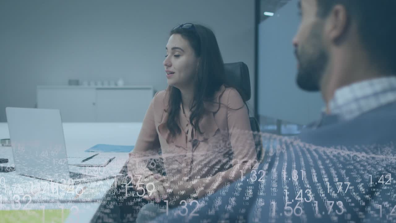Donna che si sporge in avanti e gesticola durante una riunione di lavoro spiegando dati con sovrapposizione di dati scorrevoli