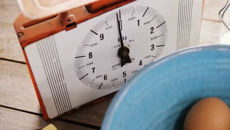 clock and brown eggs on wooden table 4k