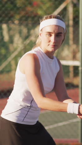 video of focused caucasian female tennis player holding racket and hitting ball