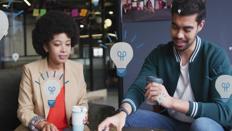 animation of lightbulb icons over smiling diverse business people talking