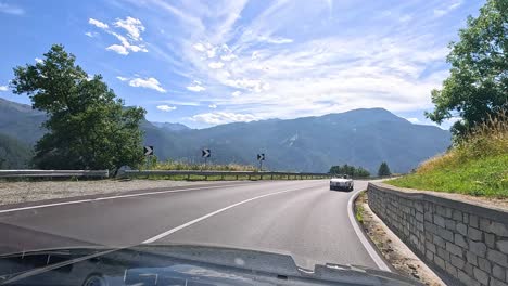 car driving through mountainous road in piedmont, italy