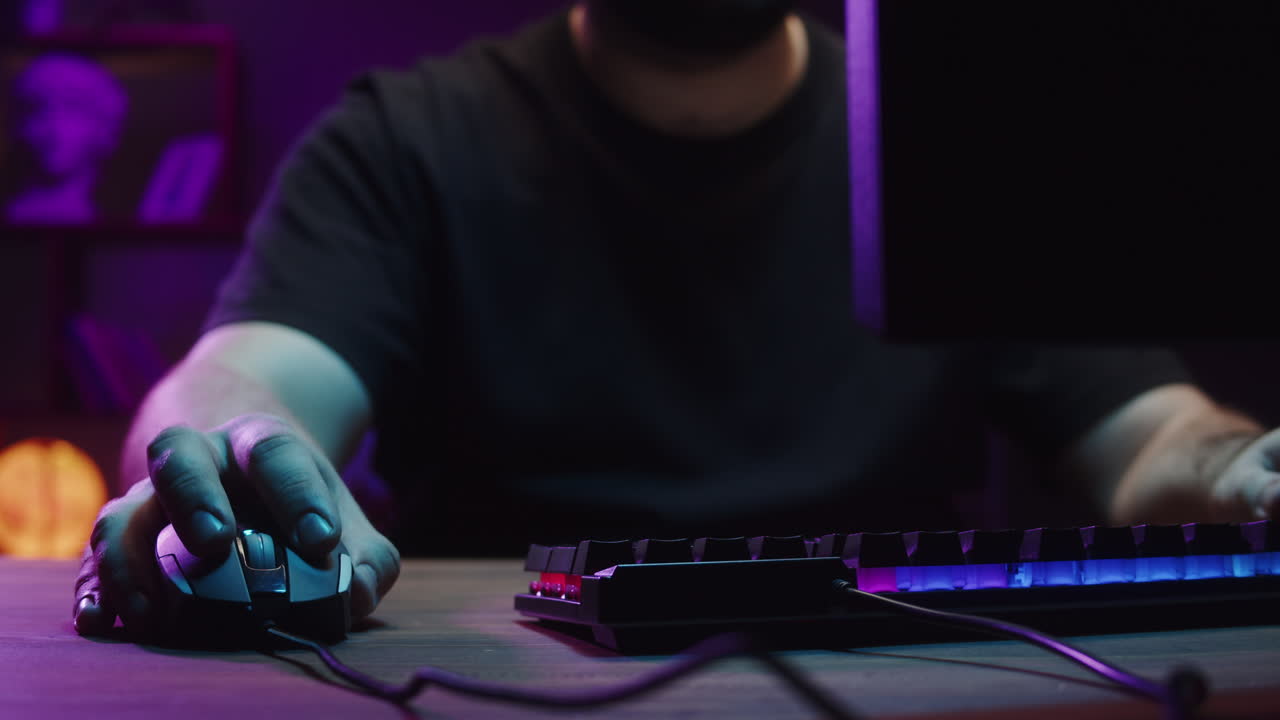 Close-up of Gamer's Hand Clicking Mouse on RGB Lit Desk