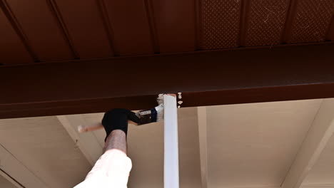 trabajador masculino imprimando madera al aire libre con pintura de imprimación blanca y pincel