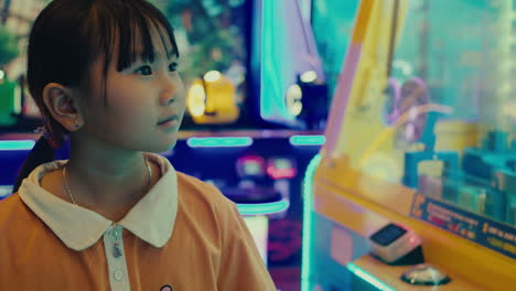 asiatic young kid girl playing video games in game room area vibrant colour amusement park