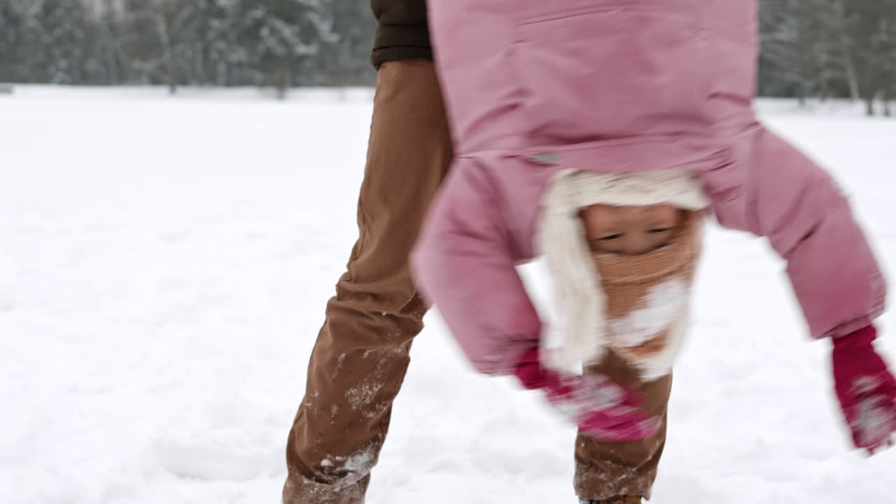 padre e hija jugando en la nieve