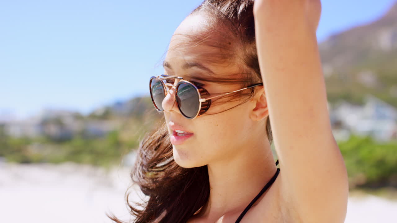 Donna con occhiali da sole su una spiaggia