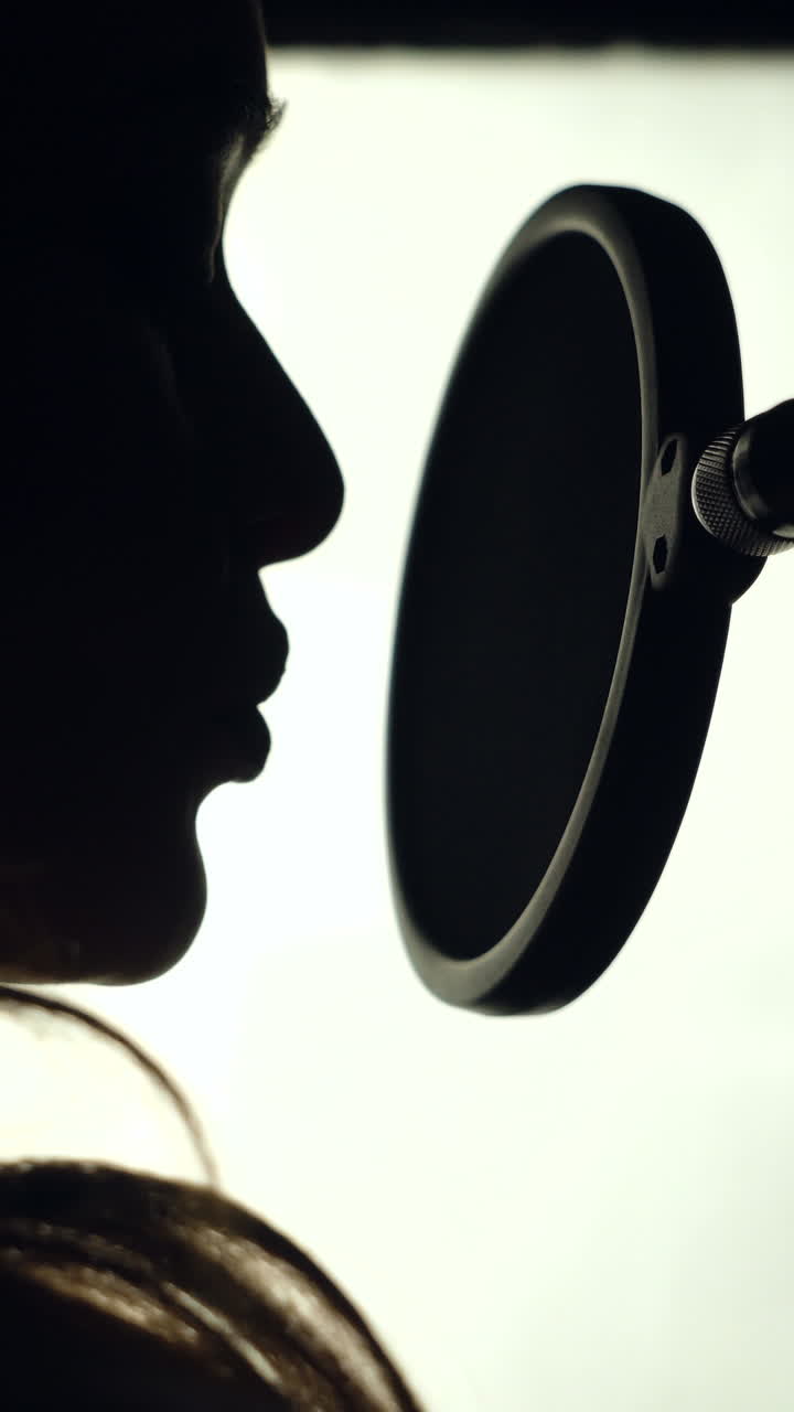 Woman singing in the recording studio. Profile of a woman with a beautiful face and lips. Black and White Vertical video