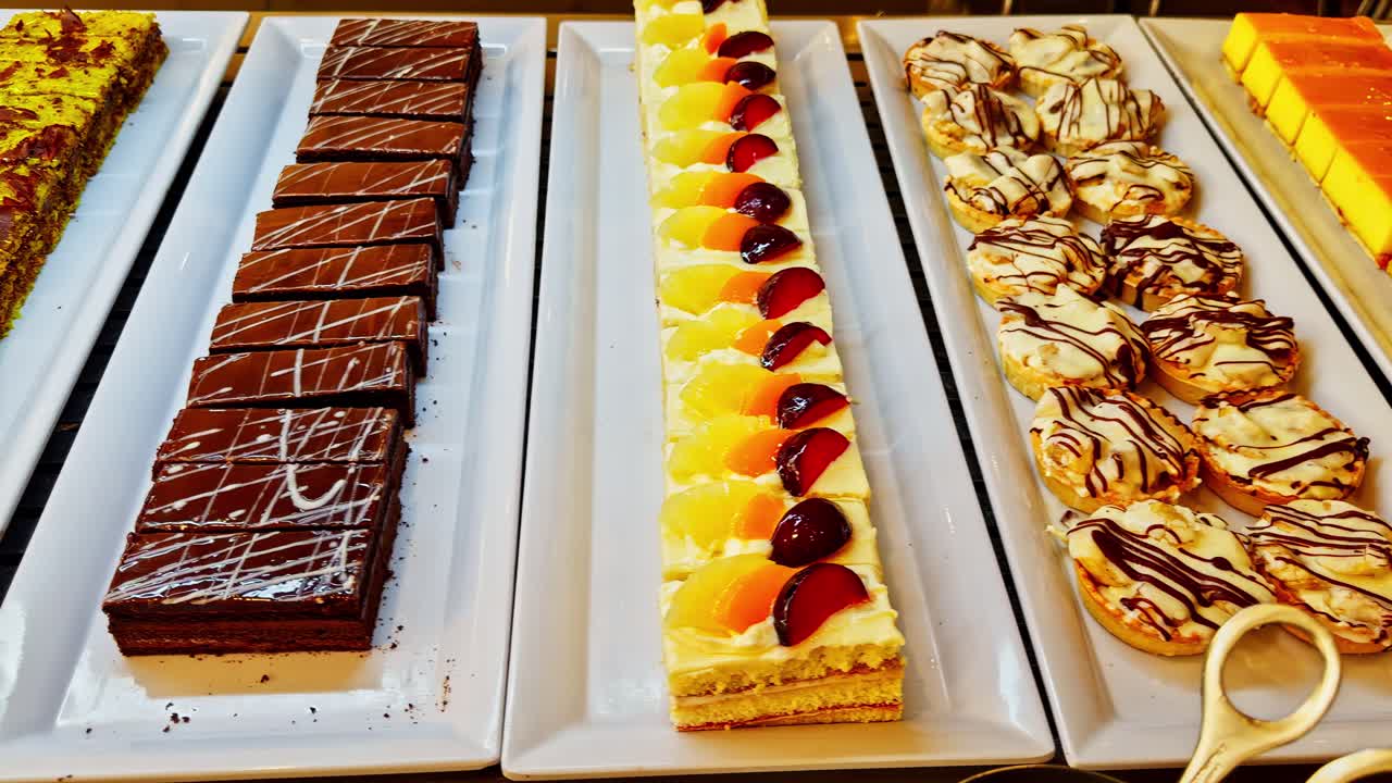 Set of industrial sweet cakes at a hotel buffet. Panning shot