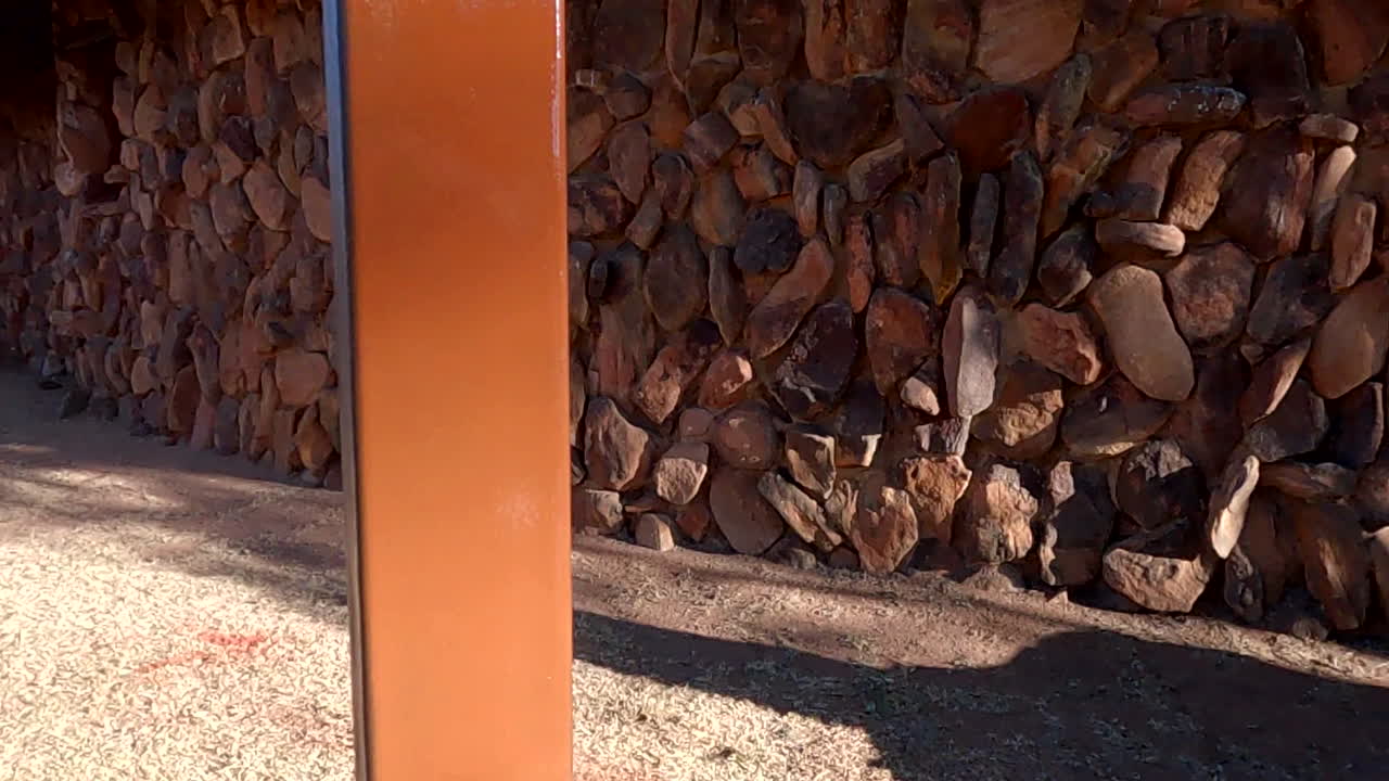 крупная распыляющая живопись металлического столба, мастерски выполненная в коричневой краске, демонстрирующая текстуру, точность и мастерство в наружной обстановке