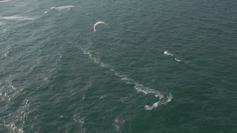 aerial view as kite surfer transitions into turn back toward beach