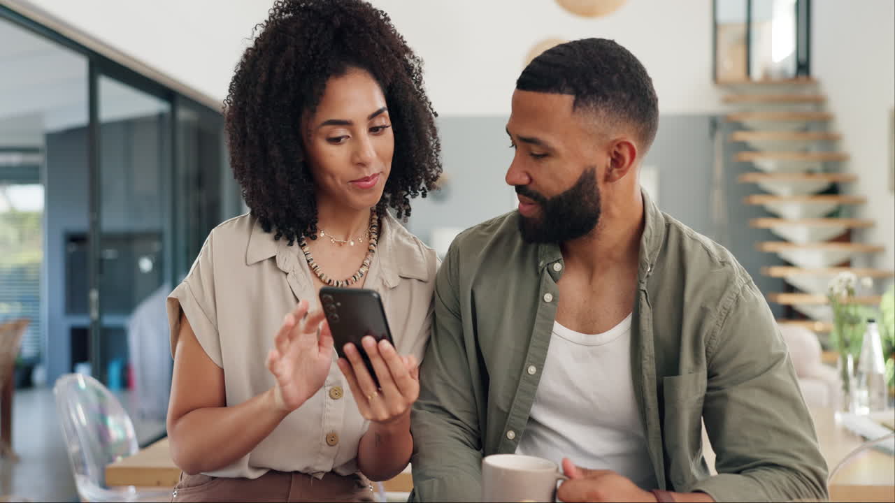 pareja mirando un teléfono inteligente durante el desayuno