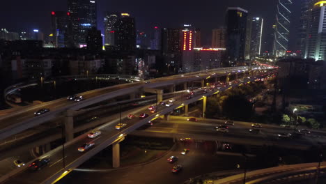 aerial shot of multi layer express road intersection at night with heavy traffic