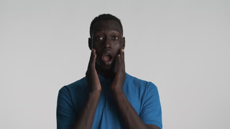 sorprendido hombre afroamericano en fondo gris.
