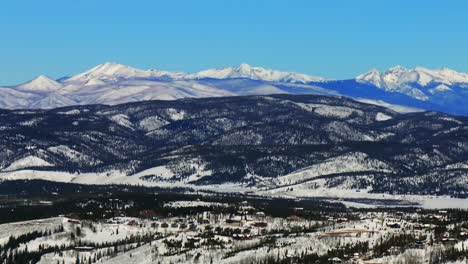 colorado rocky mountain national park fraser downtown winter park ski resort mountain town aerial drone grandby grand lake winter december snow blue sky sunny blanket of snow circle left motion