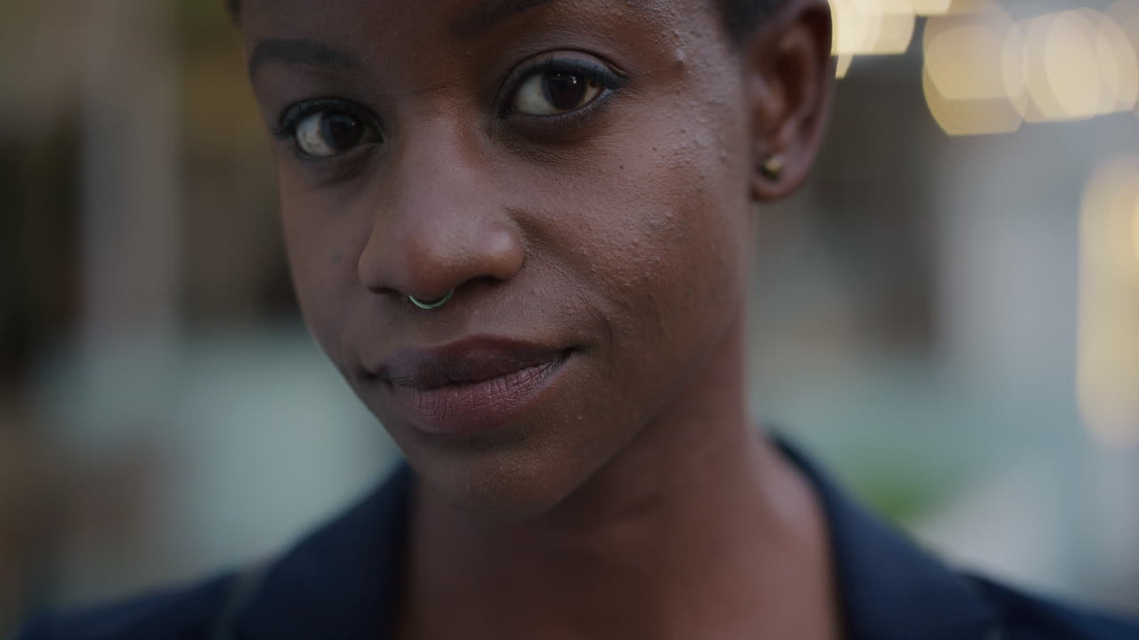 retrato de cerca hermosa mujer afroamericana gira la cabeza pareciendo seria segura de sí misma mujer negra independiente con anillo en la nariz belleza femenina en cámara lenta