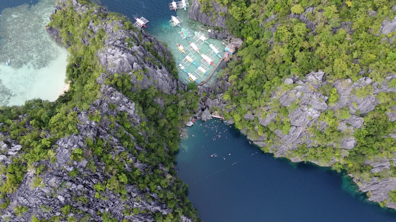 Panoramic bird's-eye aerial of tour boats and people at Barracuda lake, Coron