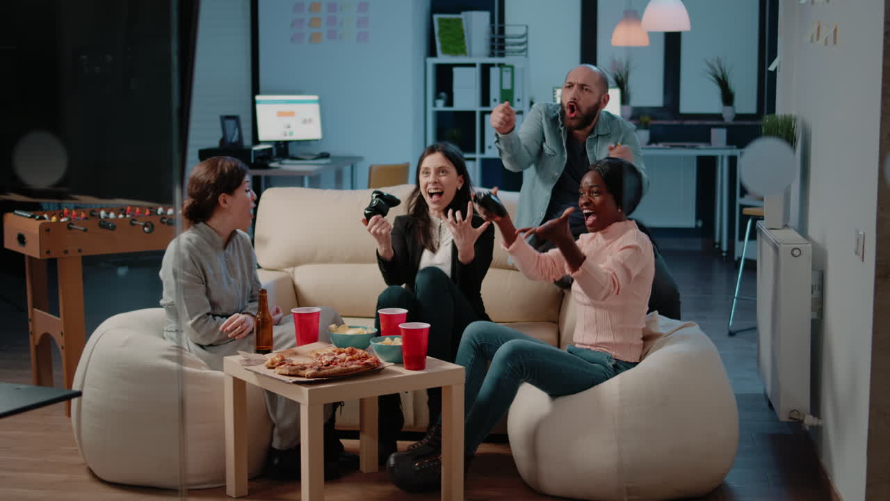 Happy colleagues playing video games on console television