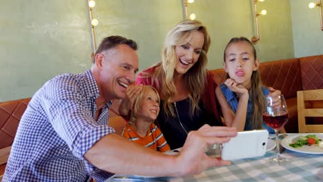 family taking selfie with mobile phone in restaurant 4k