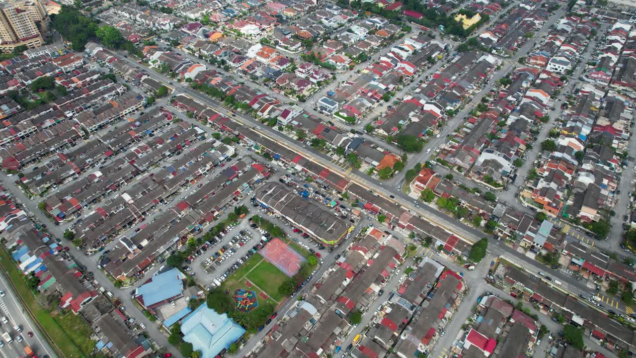 Aerial view of a residential area with houses, roads, and green spaces
