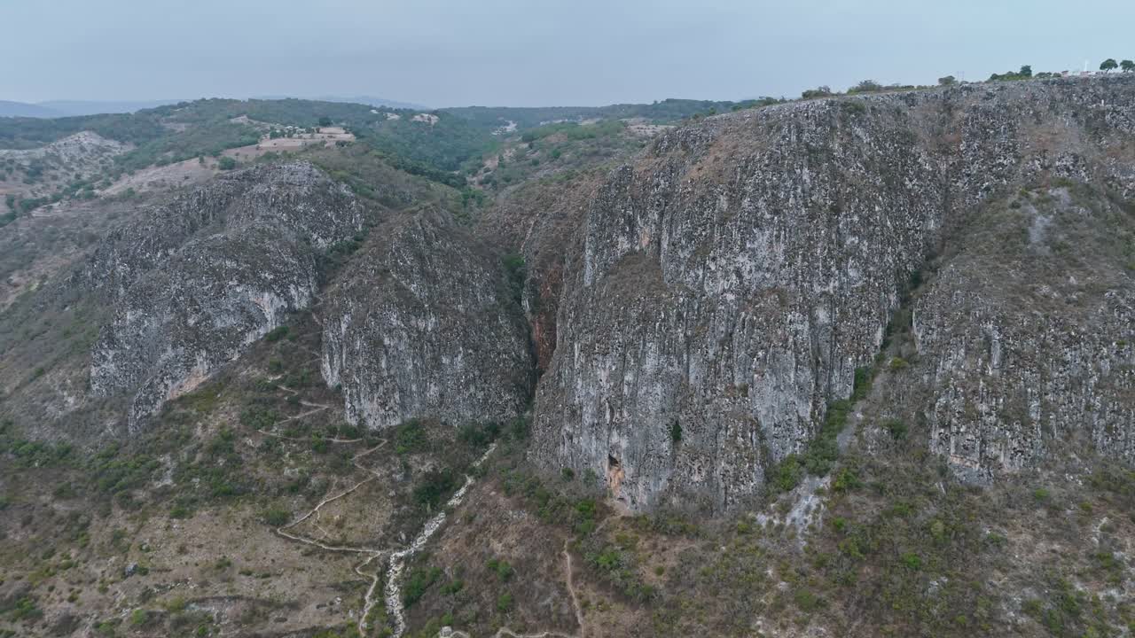 Aerial of twin canyons near Santiago Apoala with green slopes and deep cuts