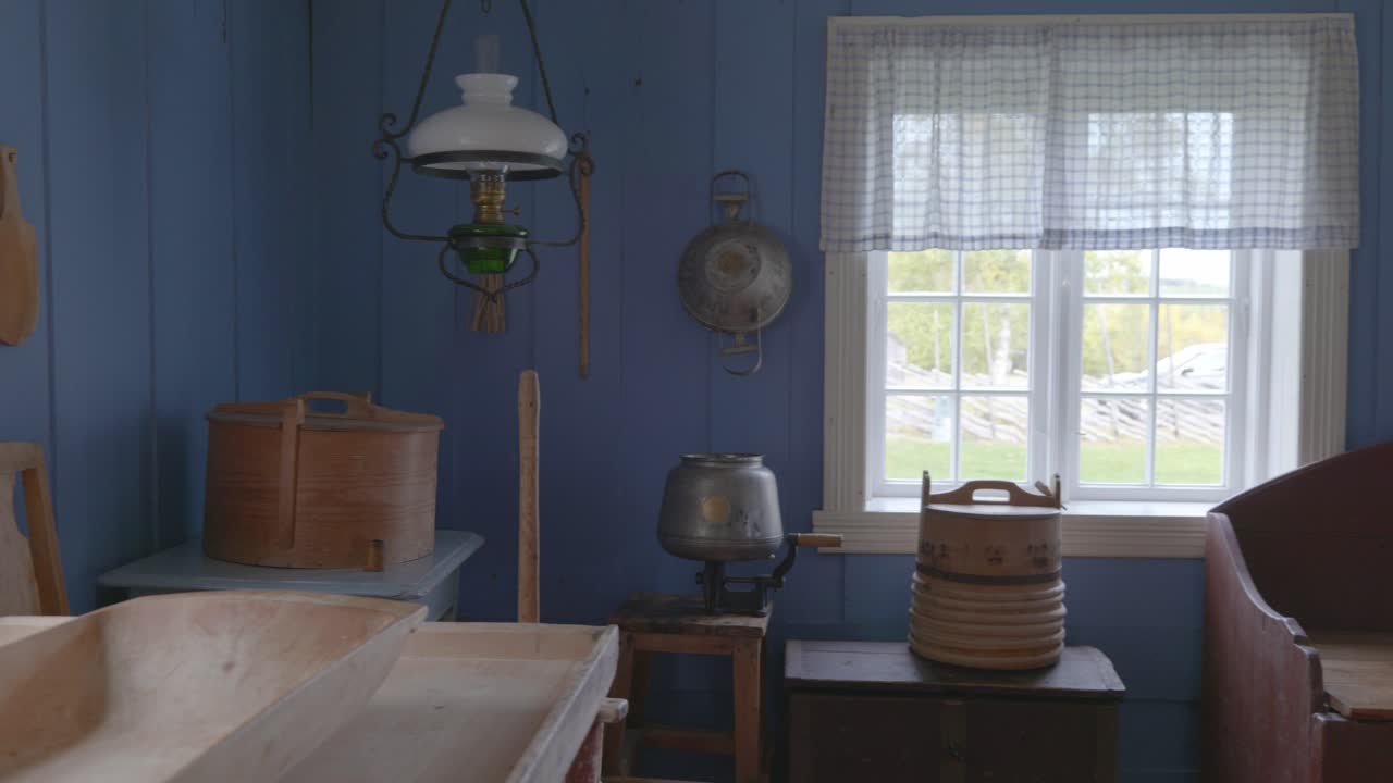 전통적인 노르웨이 목조 코티지 주방 내부의 팬 샷으로 빈티지 장비와 소박한 매력을 보여줍니다.