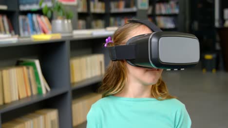 vista frontal de una colegiala caucásica usando auriculares de realidad virtual en la biblioteca de la escuela 4k