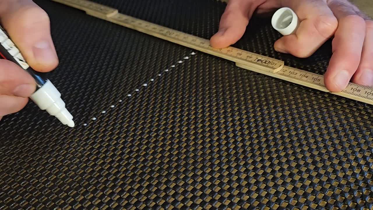 Marcatura di un tappeto di plastica con un pennarello indelebile bianco