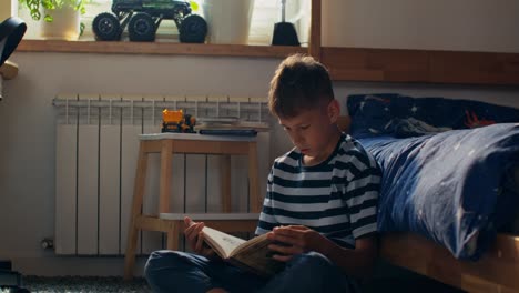 boy reading a book in his bedroom