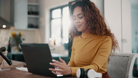 mujer trabajando en una computadora portátil en casa