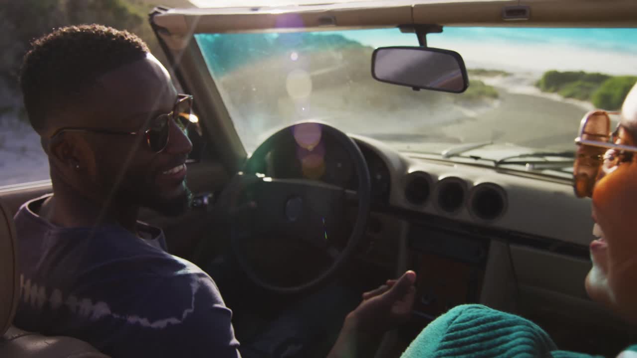 서로를 바라보고 미소 짓는 컨버터블 차에서  ⁇ 은 날 운전하는 다양한 커플