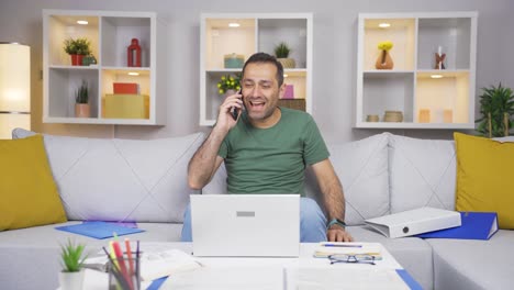 Hombre-Trabajador-De-Oficina-En-Casa-Recibiendo-Buenas-Noticias-Por-Teléfono.