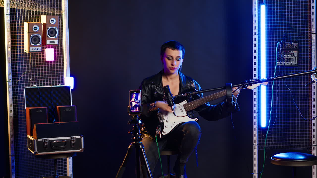 Woman performing live music with electric guitar in studio