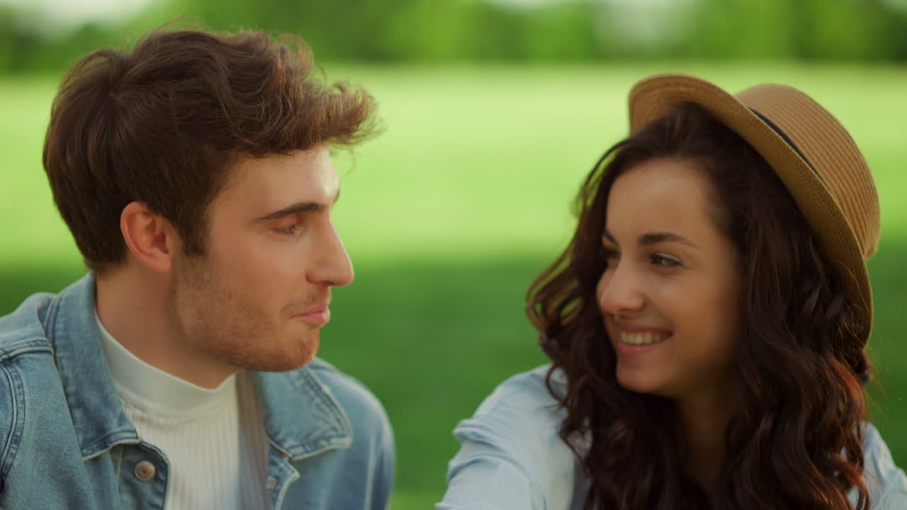 공원에서 피크닉을 하는 즐거운 소녀와 남자. 남자와 여자가 야외에서 웃고 있다.