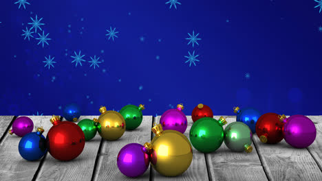 Animation-of-christmas-balls-over-snowflakes-on-blue-background