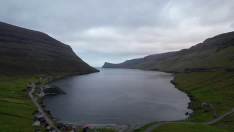 Aerial-pullback-above-Arnafjordur-and-red-roof-church-overlooking-deep-fjord