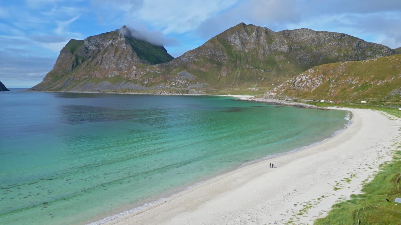 노르웨이 로포텐 섬의 하우클랜드 해변에서 여름에 산책하는 사람들 - 공중 4k 순환