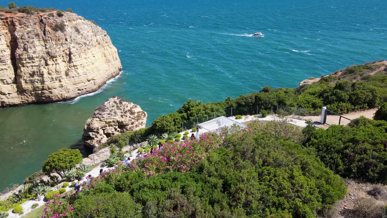 Panoramic View of Coastal Cliffs with Sea Cave and Outdoor Event in Algarve, Portugal