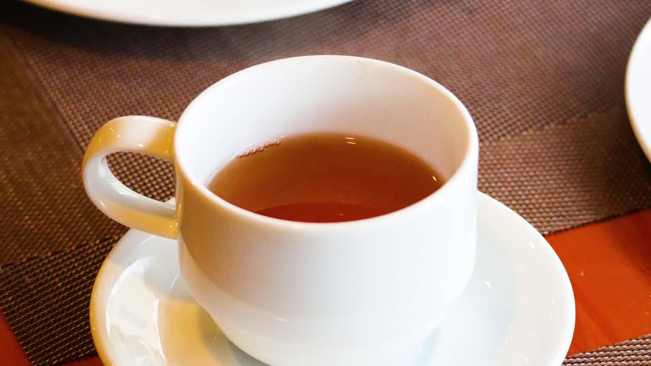 한 손 이 차 컵 을 들어 올린다