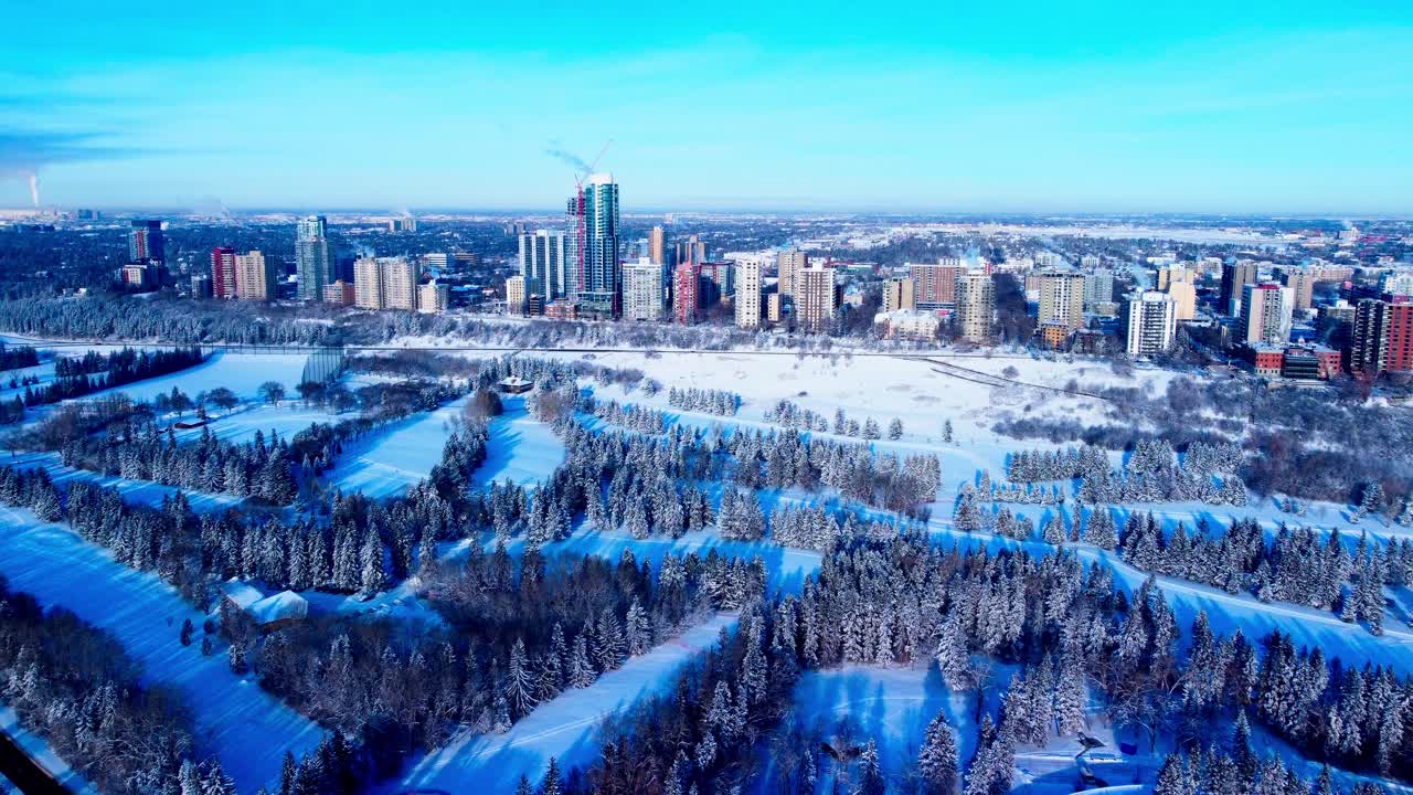 Vuelo aéreo invernal hacia adelante sobre un parque de esquí de fondo en dirección a las propiedades residenciales más lujosas del Westside de Edmonton, desde la calle 116 NW hasta la calle 125 NW, en el parque a orillas del río G1-2