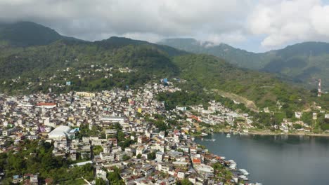 el retiro aéreo revela una impresionante ciudad en expansión en la costa del lago atitlan, guatemala.