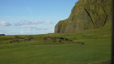 Pintoresco-Paisaje-De-La-Isla-Heimaey,-Islandia-En-Un-Día-Soleado-De-Verano,-Pastos-Verdes-Y-Acantilados-Volcánicos