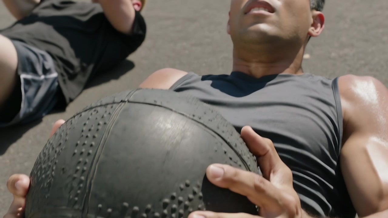 Apertando a pegada, homem de camiseta e shorts arremessando bola medicinal no asfalto para o céu para treino