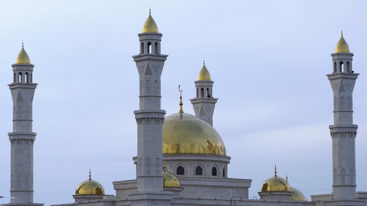 una mezquita islámica musulmana con minaretes dorados y una media luna contra el cielo. un templo religioso para orar y adorar al dios de los musulmanes en la cultura islámica y la creencia en allah.video 4k zoom