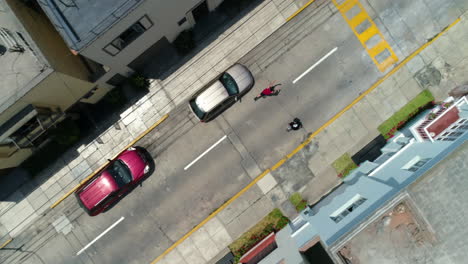 Aerial-view-above-men-skating-through-the-streets-of-Lima