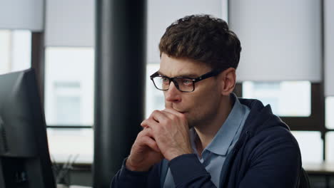 Focused manager look screen at workplace closeup. Serious programmer analyzing