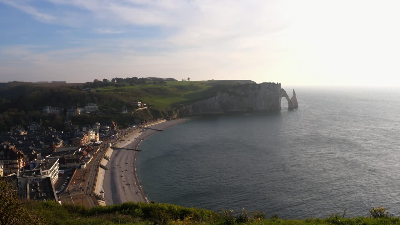 fotografía aérea de la hermosa playa de etretat y la famosa formación rocosa de tiza blanca en la costa en el fondo durante la puesta de sol