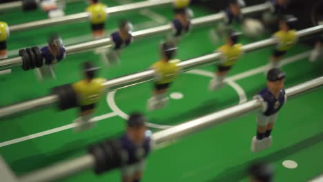 close-up of people playing retro foosball game