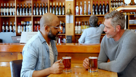 amigos brindando un vaso de cerveza en el bar 4k
