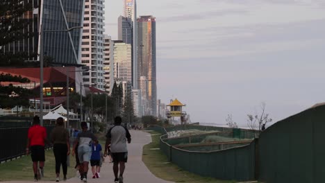 people jogging in a city park during evening